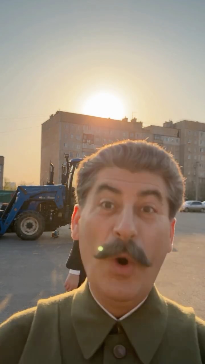 Moustached Soviet-era figure vlogs to camera beside a tractor
